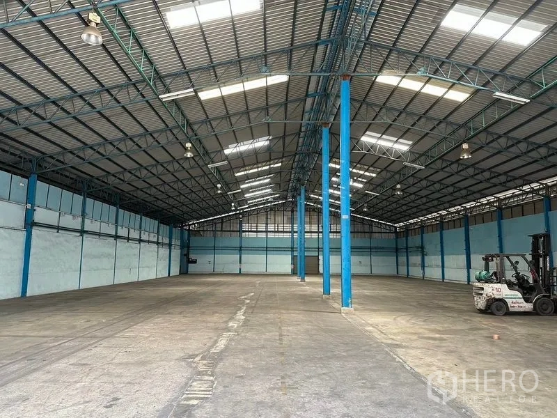 货栈 出租在Bang Pa-in, Phra Nakhon Si Ayutthaya - 开阔的仓库大厅，蓝色钢柱与屋面采光，侧边停有叉车。