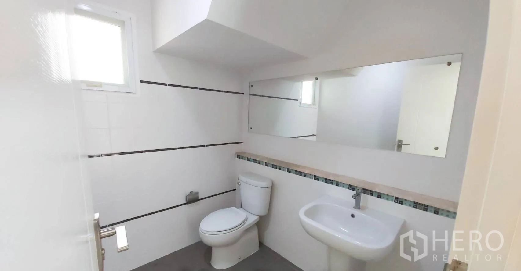 บ้าน for sale in Bang Kapi, Bangkok - ห้องน้ำโทนขาวสะอาด พร้อมโถสุขภัณฑ์ อ่างล้างหน้า และกระจกยาวเต็มผนัง