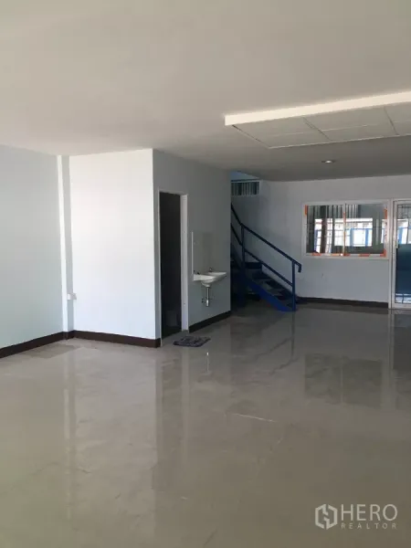 คลังสินค้า ให้เช่าในBueng Kum, Bangkok - โซนออฟฟิศชั้นล่างสว่าง พื้นกระเบื้องเงา อ่างล้างมือ และบันไดสีน้ำเงิน