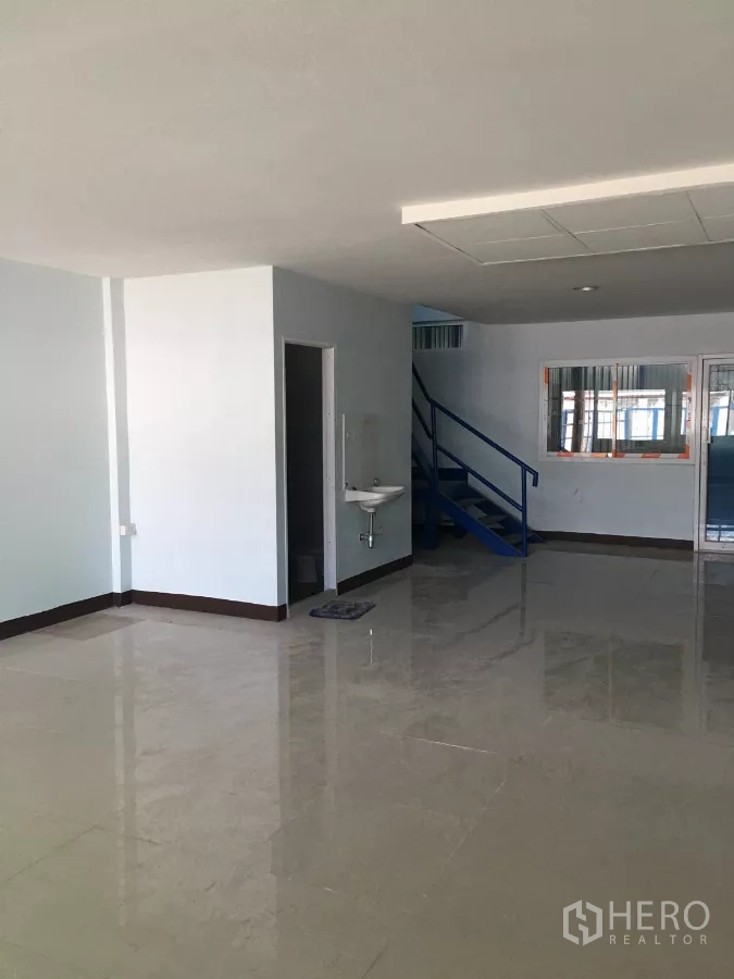 คลังสินค้า ให้เช่าในBueng Kum, Bangkok - โซนออฟฟิศชั้นล่างสว่าง พื้นกระเบื้องเงา อ่างล้างมือ และบันไดสีน้ำเงิน