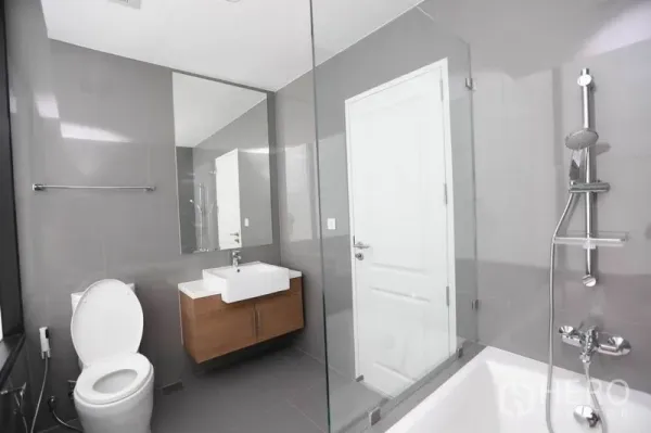 คอนโด ให้เช่าหรือขายในBang Rak, Bangkok - ห้องน้ำที่สอง มีอ่างอาบน้ำ ฝักบัวกั้นด้วยกระจก และอ่างล้างหน้าแบบแขวน