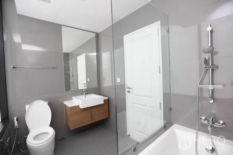 คอนโด ให้เช่าหรือขายในBang Rak, Bangkok - ห้องน้ำที่สอง มีอ่างอาบน้ำ ฝักบัวกั้นด้วยกระจก และอ่างล้างหน้าแบบแขวน