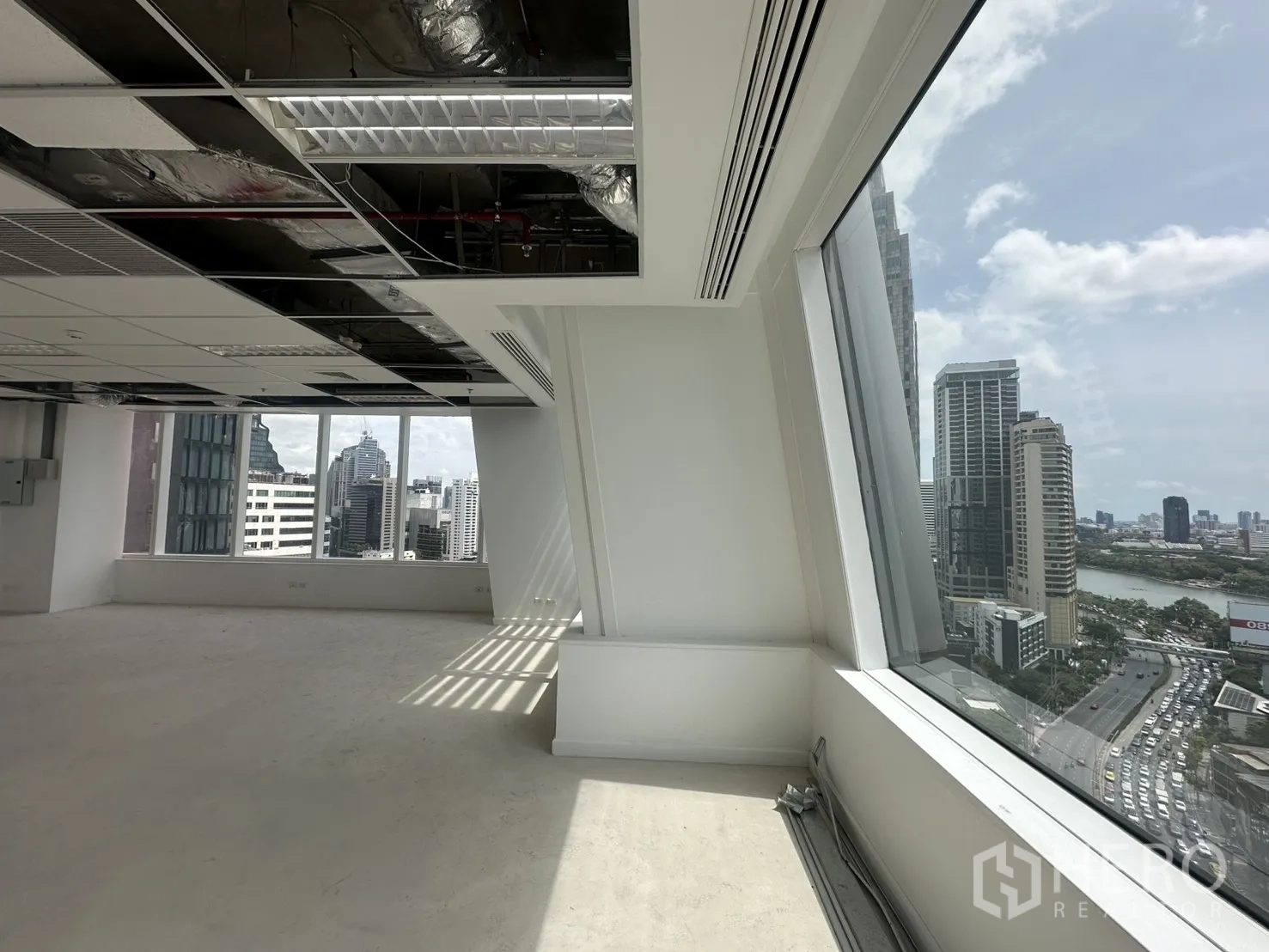 ออฟฟิศ for rent in Watthana, Bangkok - มุมหน้าต่างเอียงเห็นอาคารสูงและสวนที่มีบึงน้ำใกล้เคียง