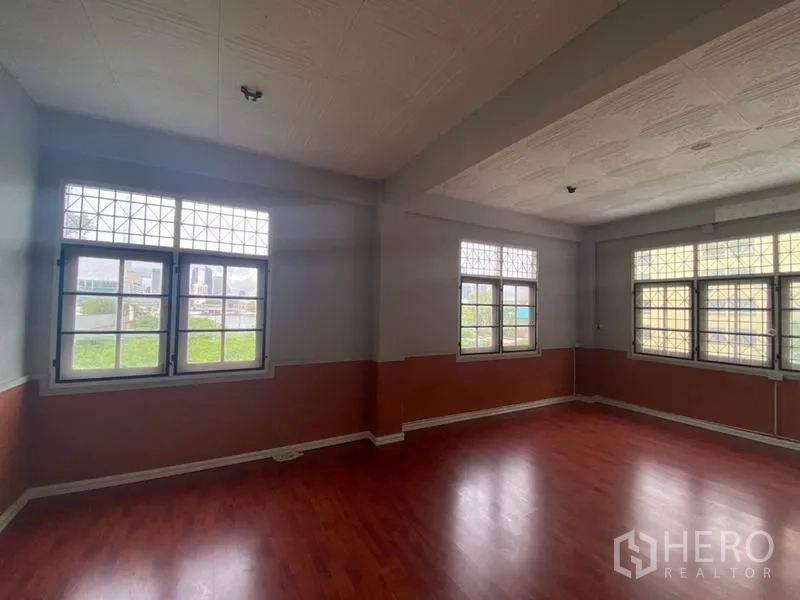 Retail Space for rent in Khlong San, Bangkok - Spacious multipurpose room with multiple windows and wood floors.