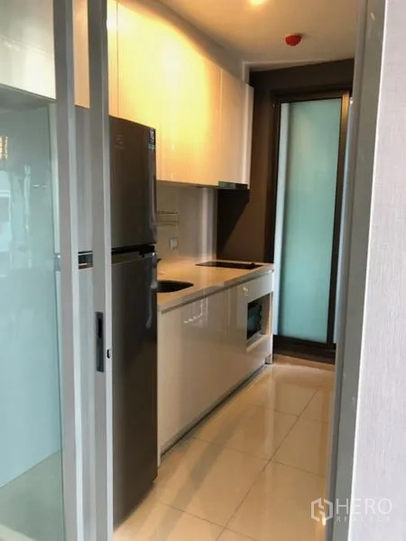 คอนโด ให้เช่าในKhlong Toei, Bangkok - ครัวแบบแกลเลย์กะทัดรัด พร้อมตู้บิลต์อิน เตาอบ เตาไฟฟ้า และตู้เย็น