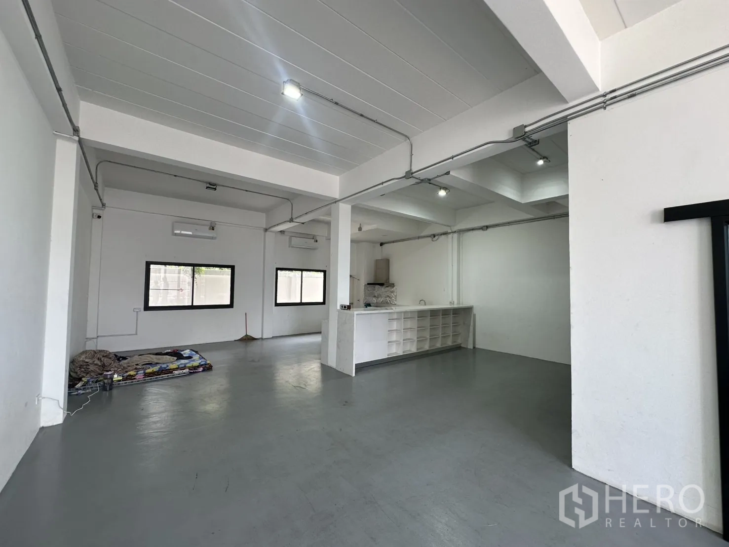 带办公室的家 出租或出售在Bang Na, Bangkok - 宽敞办公区，外露管线、灰色地面与内置吧台