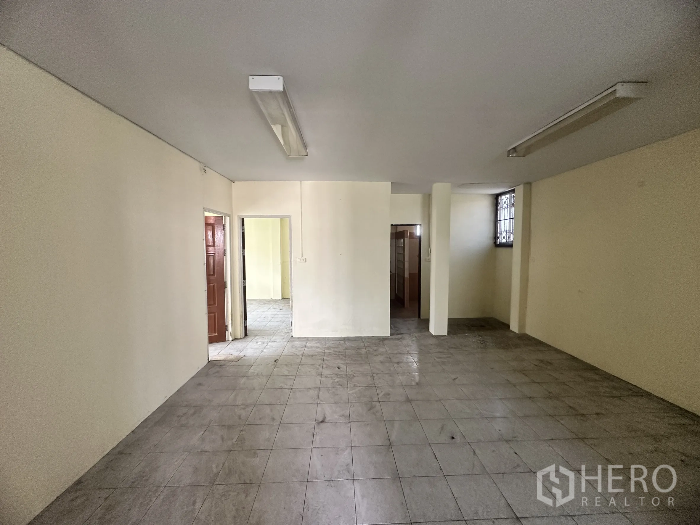 Factory for sale in Bang Bua Thong, Nonthaburi - Large tiled office floor with multiple doorways and neutral walls.