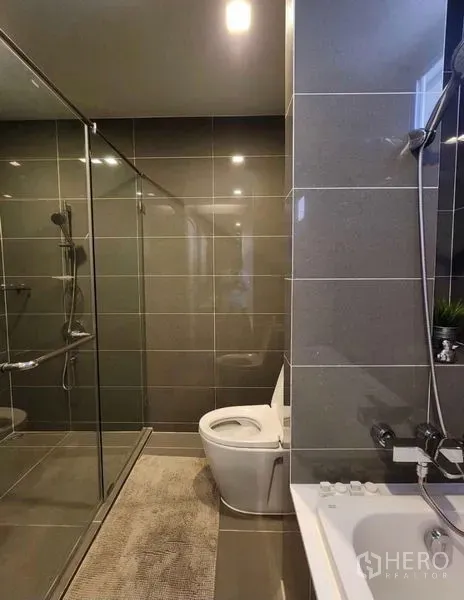 คอนโด ให้เช่าในWatthana, Bangkok - ห้องน้ำโทนเทา มีกระจกกั้นอาบน้ำ โถสุขภัณฑ์ และริมอ่าง