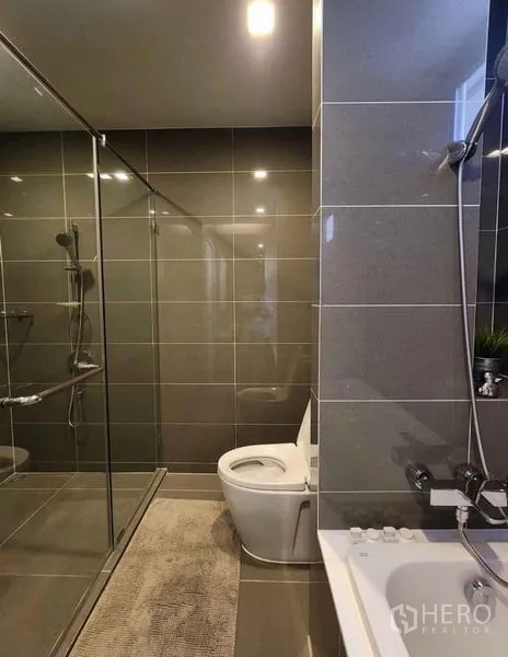 คอนโด ให้เช่าในWatthana, Bangkok - ห้องน้ำโทนเทา มีกระจกกั้นอาบน้ำ โถสุขภัณฑ์ และริมอ่าง