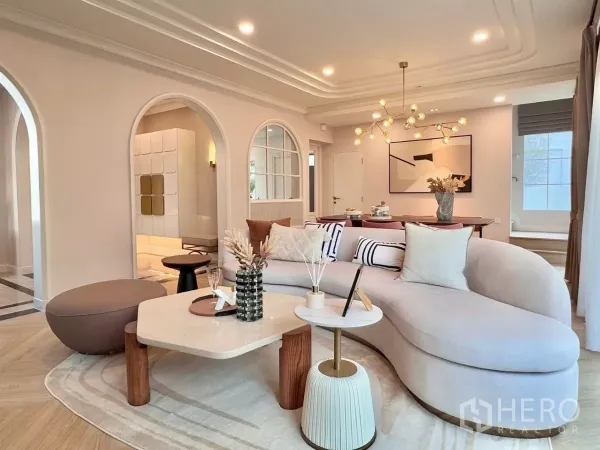 Detached House for rent in Bang Phli, Samut Prakan - Lounge with a curved sofa, coffee tables and sculptural pendant lighting.