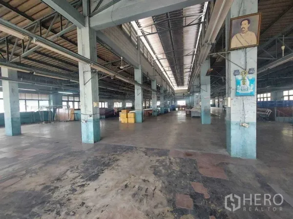 Warehouse for rent in Min Buri, Bangkok - Large open-plan factory hall with central skylight, rows of columns and durable concrete flooring.