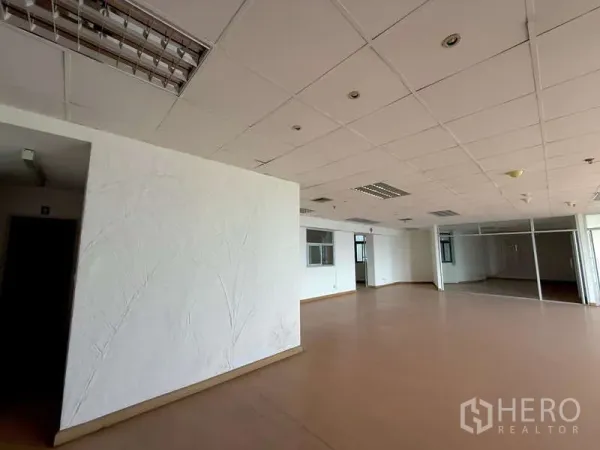 办公空间 出租在Chatuchak, Bangkok - 办公室一角，白色纹理特色墙与玻璃隔断会议室，未配家具。