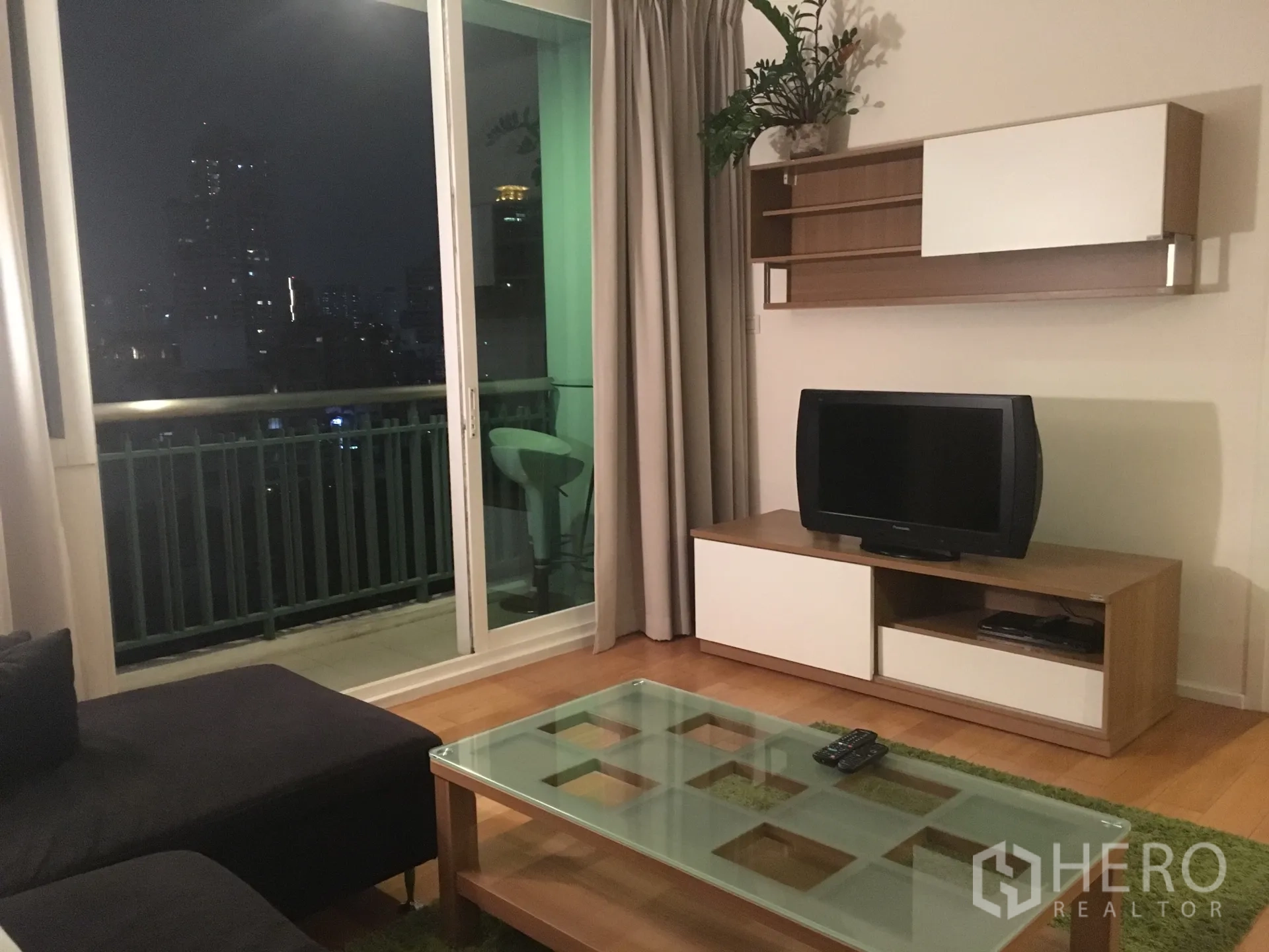 คอนโด ให้เช่าในWatthana, Bangkok - ห้องนั่งเล่นพร้อมโซฟา ชั้นวางทีวี และประตูกระจกบานเลื่อนออกสู่ระเบียง