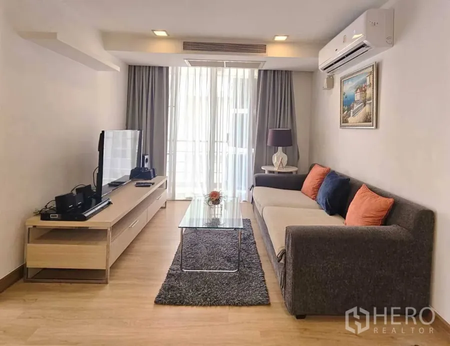 คอนโด ให้เช่าในWatthana, Bangkok - ห้องนั่งเล่นสว่าง โซฟายาว ตู้ทีวี โต๊ะกระจก และประตูกระจกไประเบียง