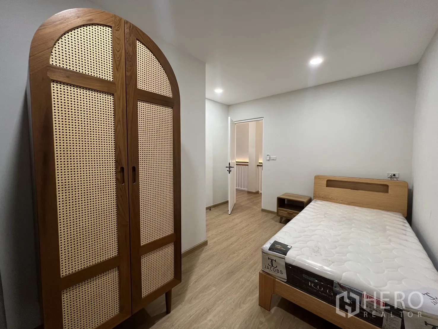 Detached House for rent in Saphan Sung, Bangkok - Second bedroom with bedside table, wood floor and soft lighting.