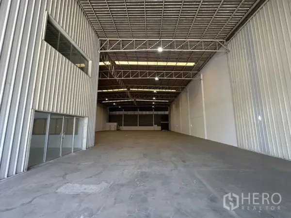 工厂 出租在Khlong Luang, Pathum Thani - 宽敞仓库内部，高钢桁架屋顶、采光板与混凝土地坪。