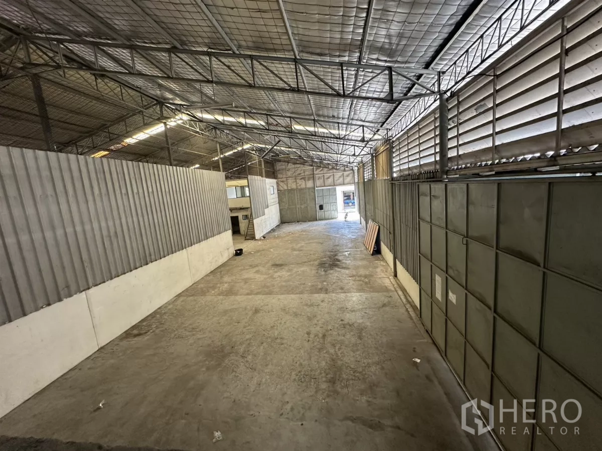 Warehouse for rent in Suan Luang, Bangkok - Long aisle with louvered side vents and metal panel walls for airflow.
