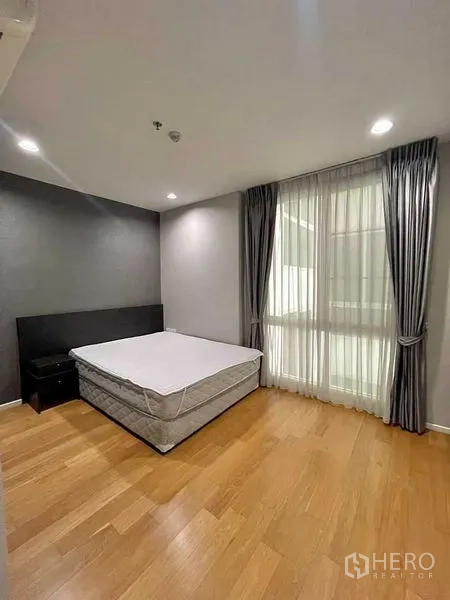 公寓 出租在Watthana, Bangkok - 主卧配大窗与纱帘、木地板和大床，采光充足。