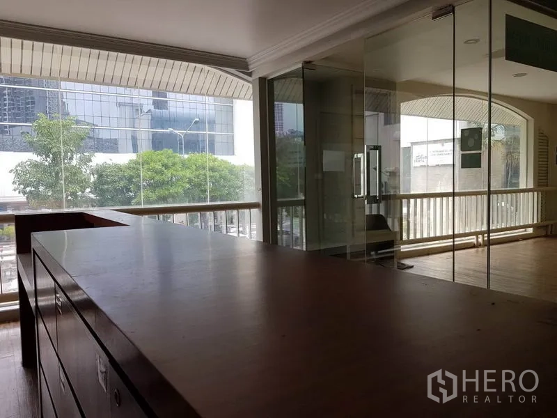 零售空间 出租在Khlong Toei, Bangkok - 开放式商铺区，内置木柜台、玻璃会议间与落地窗。