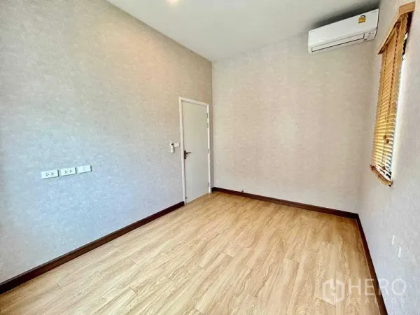 Detached House for rent in Khlong Sam Wa, Bangkok - Compact bedroom with wood floor, air conditioner and white door