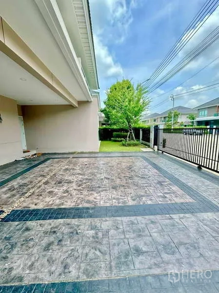 บ้าน ขายในLat Krabang, Bangkok - ที่จอดรถในร่มและทางเข้าบ้านปูพื้นกระเบื้องข้างสนามหญ้าหน้าบ้าน