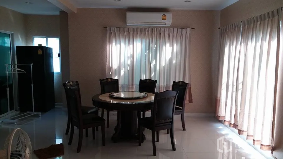 Detached House for rent in Pathum Thani - Bright dining area with round table, full-length curtains and wall-mounted air conditioner
