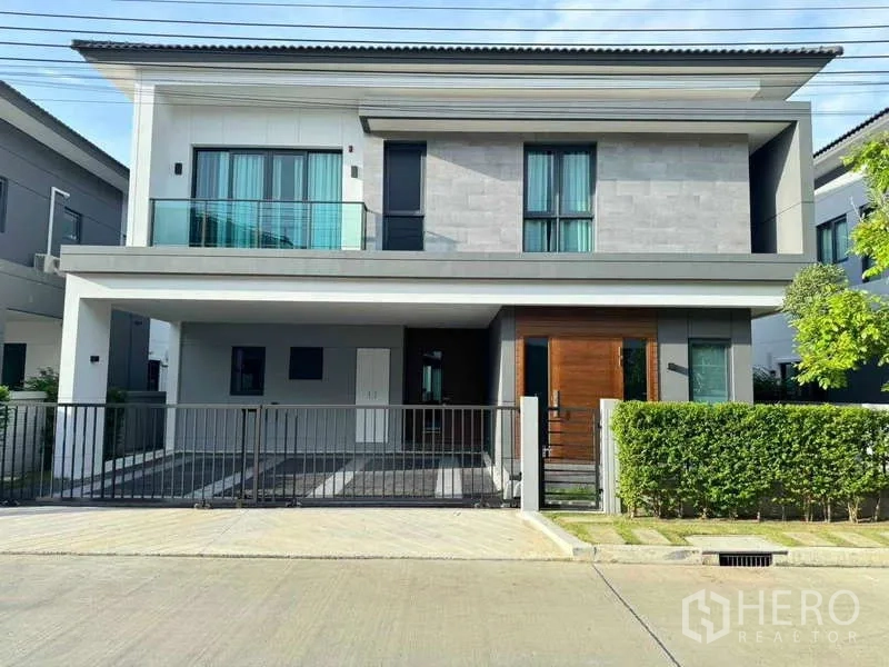 Detached House for rent or sale in Bang Phli, Samut Prakan - Contemporary two-storey detached house facade with balcony, double carport and gated front yard.