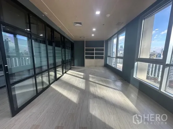 Office Space for rent in Bang Rak, Bangkok - Corner executive room with built-in shelving and panoramic city views through tall windows.