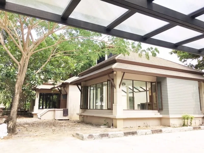 Detached House for rent in Khlong Toei, Bangkok - Exterior of detached house with large corner windows under mature trees and a covered carport.