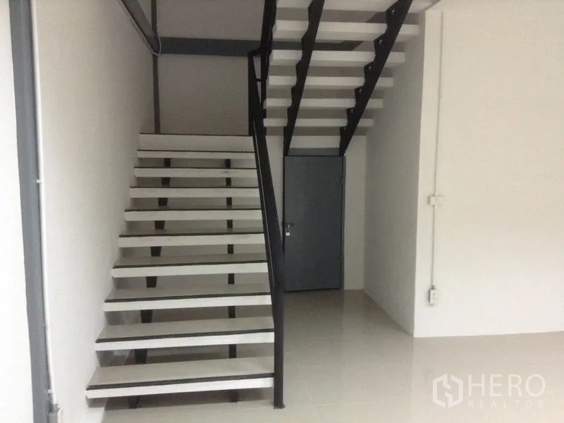 คลังสินค้า ให้เช่าในBang Kapi, Bangkok - ภาพระยะใกล้ของบันไดเหล็กขึ้นชั้นบน พร้อมประตูเก็บของใต้บันได