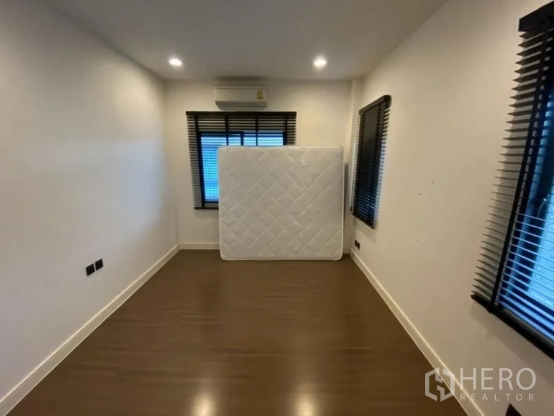 Detached House for rent in Bang Kapi, Bangkok - Secondary bedroom with wood flooring, window blinds and air conditioner.