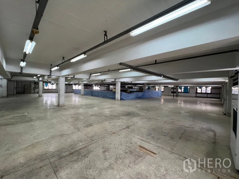 Warehouse for rent in Bang Kapi, Bangkok - Large clear-span floor with beams and bright ceiling lights ready for logistics operations.