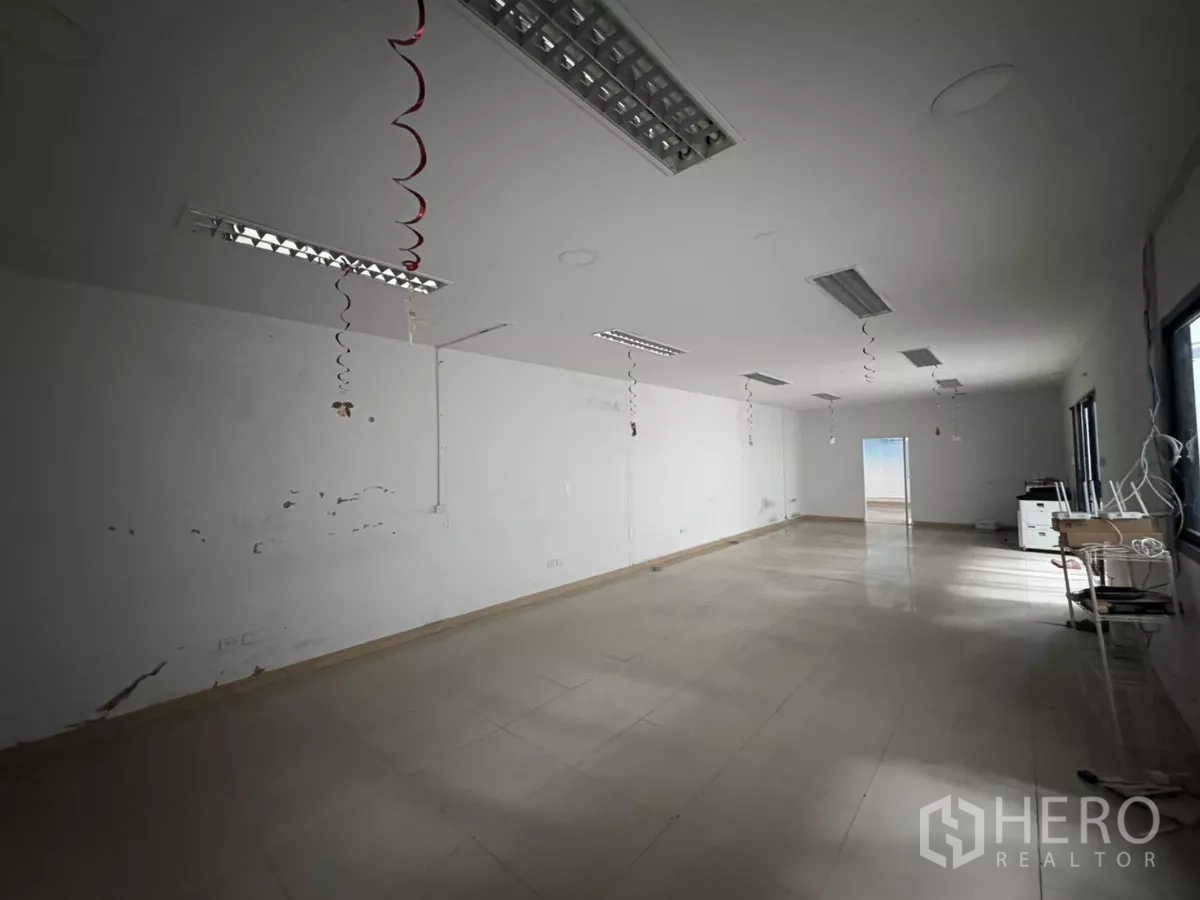 คลังสินค้า ให้เช่าในBang Phli, Samut Prakan - ห้องออฟฟิศทรงลึก พื้นเงา และไฟฟลูออเรสเซนต์แขวน.