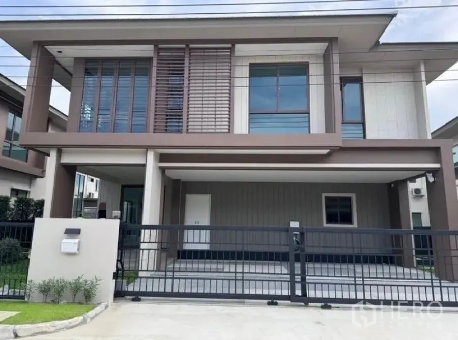 Detached House for rent in Bang Kapi, Bangkok - Front exterior of a modern two-storey detached house with sliding gate and covered carport.