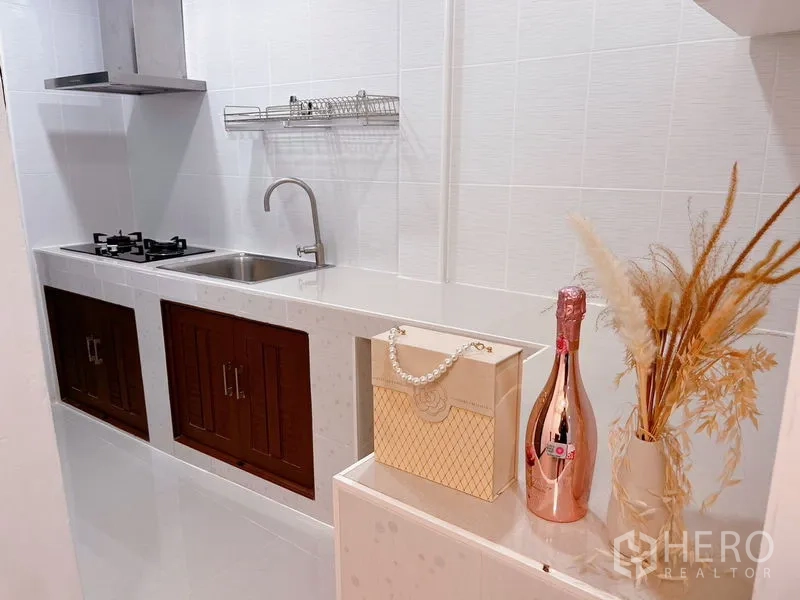 联排别墅 出租在Huai Khwang, Bangkok - 白色廊式厨房，燃气灶、洗菜盆与瓷砖防溅板。