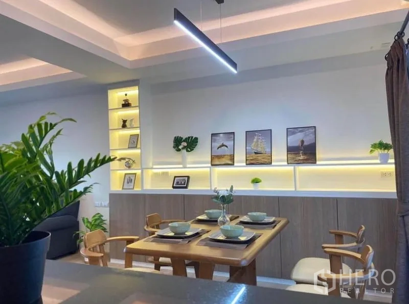 联排别墅 出租在Prawet, Bangkok - 餐厅视角，线性吊灯与展示搁架。