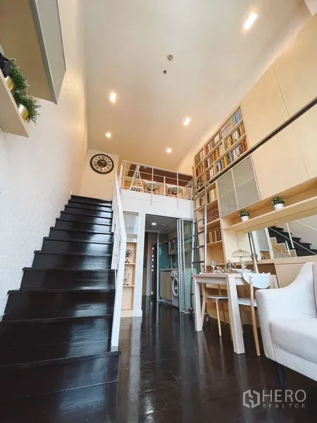 公寓 出租或出售在Khlong Toei, Bangkok - 玄关走道与黑色楼梯通往夹层，餐区及玻璃隔断小厨房。