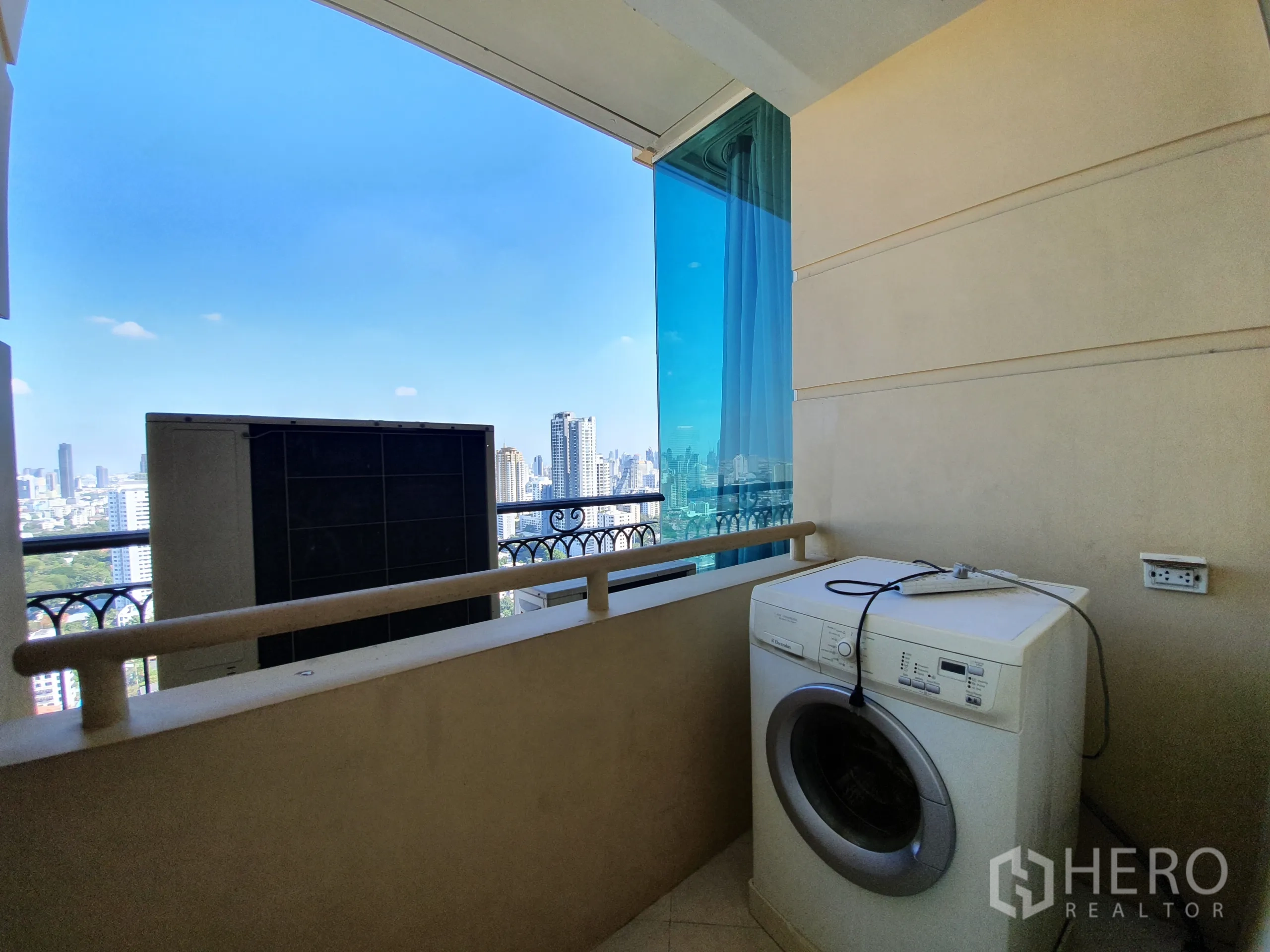 公寓 出租在Watthana, Bangkok - 生活阳台放置洗衣机，可眺望城市景致。