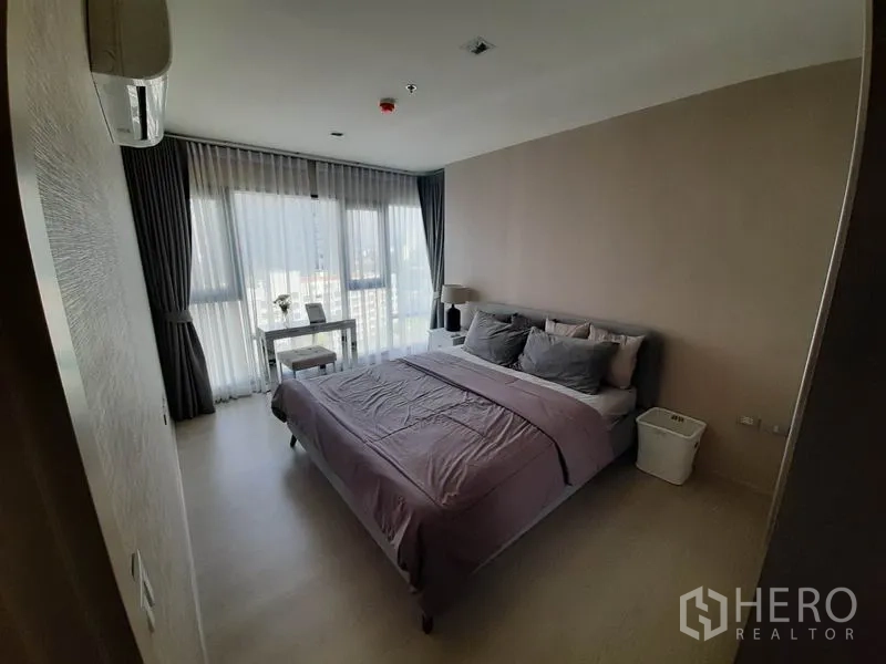 คอนโด ให้เช่าหรือขายในKhlong Toei, Bangkok - ห้องนอนสว่าง มีหน้าต่างบานใหญ่ วิวเมือง เตียง และโต๊ะทำงานเล็ก