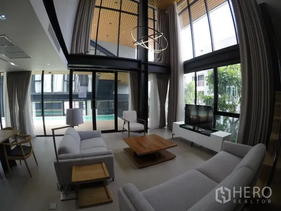 อพาร์ทเมนท์ ให้เช่าในKhlong Toei, Bangkok - ห้องนั่งเล่นเพดานสูง กระจกบานใหญ่ โซฟาสีเทา มองเห็นระเบียงสระว่ายน้ำ