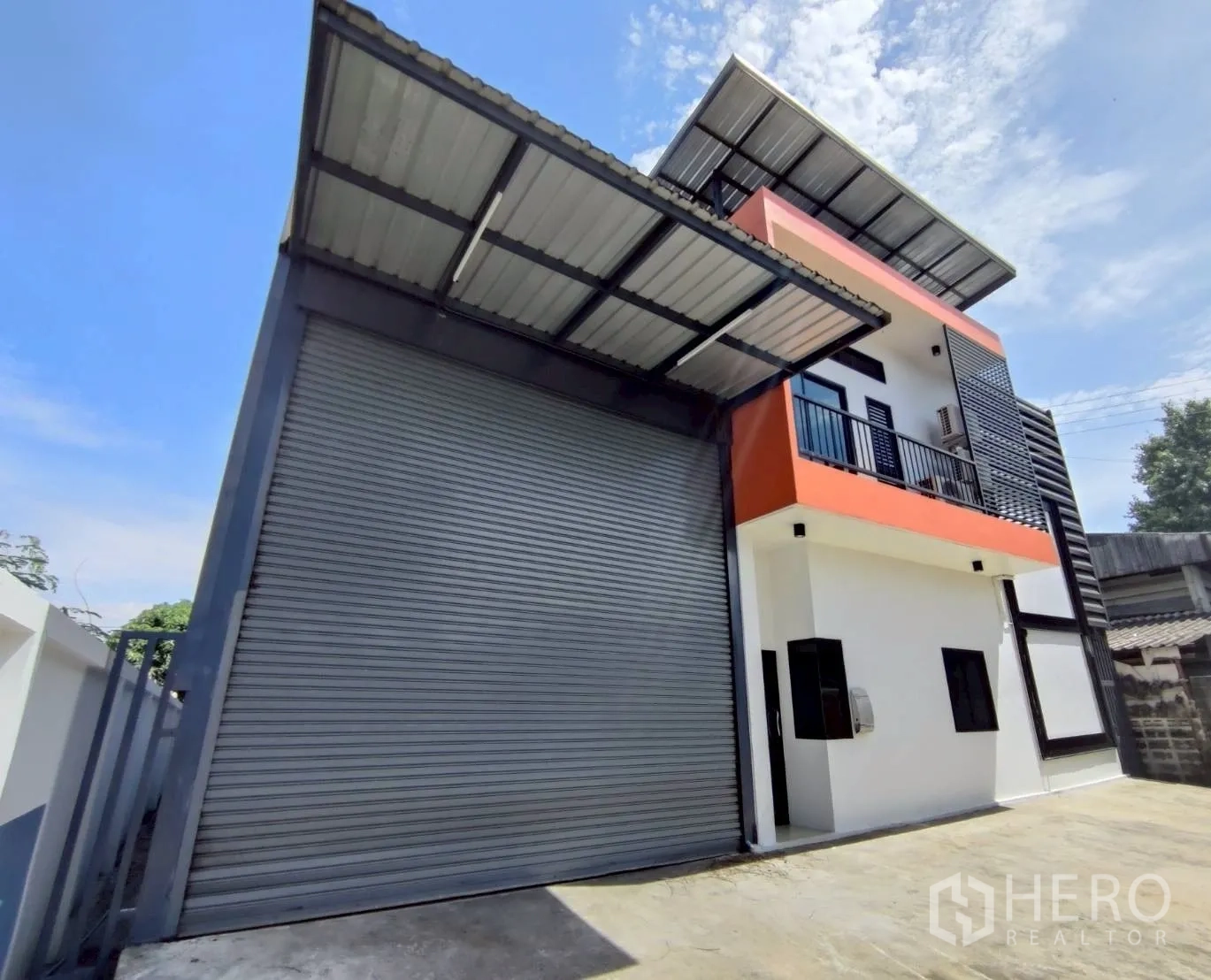 โกดัง for rent in Lam Luk Ka, Pathum Thani - มุมภายนอกแสดงประตูม้วนขนาดใหญ่และกันสาดลานขนถ่ายสินค้า.