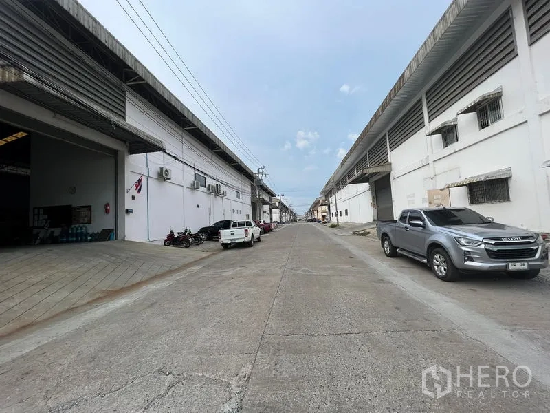 คลังสินค้า ให้เช่าในBang Sao Thong, Samut Prakan - ถนนในนิคมอุตสาหกรรมมีโกดังสองฝั่งและรถกระบะจอด