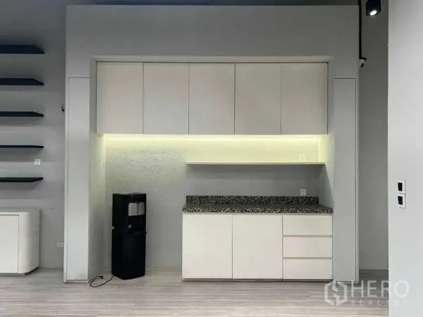 Retail Space for rent - Built-in white pantry with LED under-cabinet lighting and stone countertop inside a modern retail unit.