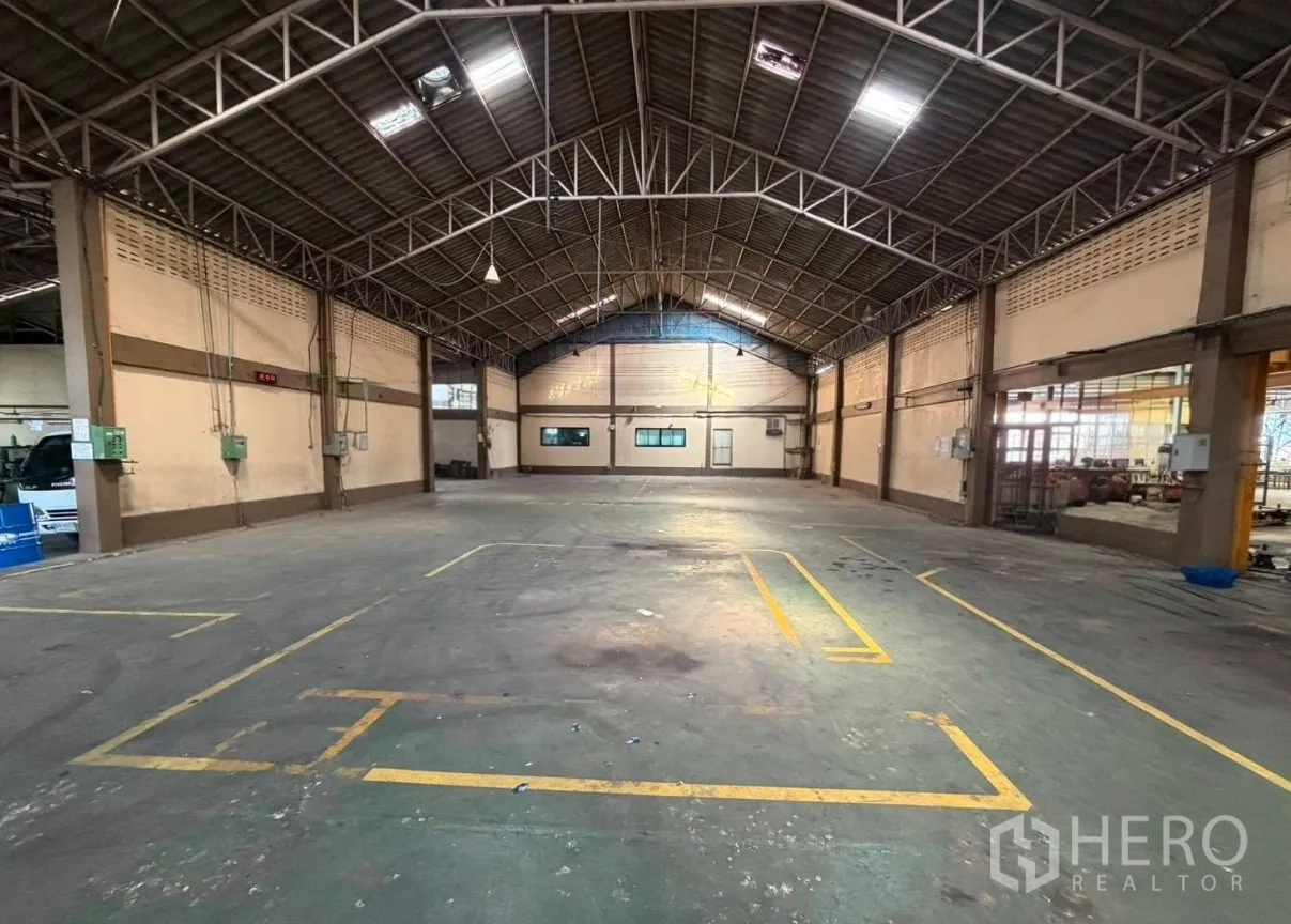 โรงงาน for rent in Bang Phli, Samut Prakan - คลังสินค้าหลังคาทรงโค้ง วางโครงเหล็ก มีเส้นแบ่งโซนงานและช่องหน้าต่างข้าง