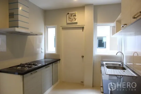 独立式住宅 出租在Bang Na, Bangkok - 封闭式厨房，燃气灶、抽油烟机、宽大台面与双水槽