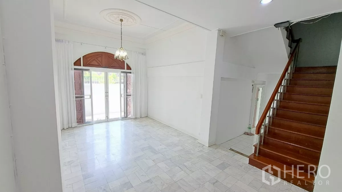 Townhouse for rent in Watthana, Bangkok - Front lounge with high ceiling, arched double doors and staircase.