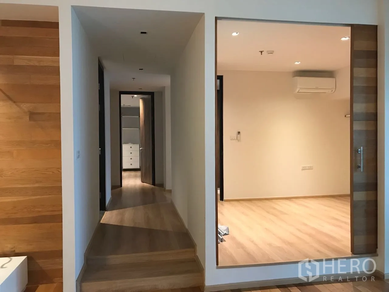 คอนโด ให้เช่าในKhlong Toei, Bangkok - โถงทางเดินมีสเต็ป เชื่อมห้องกระจก พื้นไม้ต่อเนื่องทั่วพื้นที่