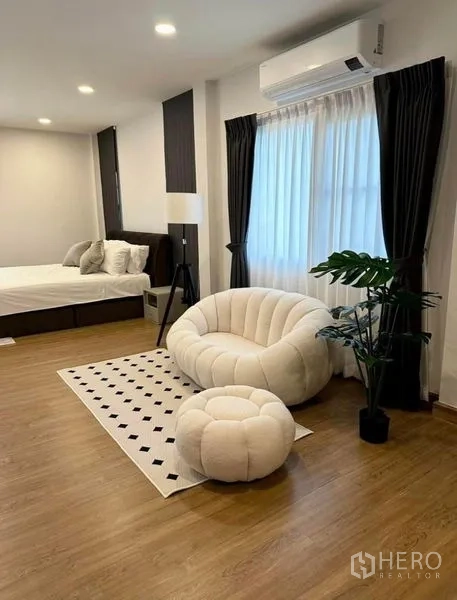 Detached House for rent in Bang Phli, Samut Prakan - Cozy bedroom corner featuring a plush chair and ottoman beside the bed with air conditioning.