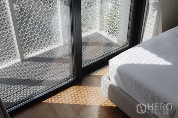 ทาวน์เฮาส์ ให้เช่าหรือขายในWatthana, Bangkok - ระเบียงห้องนอนพร้อมฉากลายฉลุทอดเงาลายบนพื้นไม้