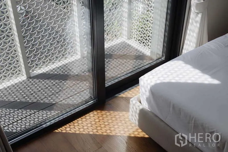 ทาวน์เฮาส์ ให้เช่าหรือขายในWatthana, Bangkok - ระเบียงห้องนอนพร้อมฉากลายฉลุทอดเงาลายบนพื้นไม้